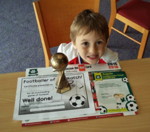 Aaron with his medals and certificates